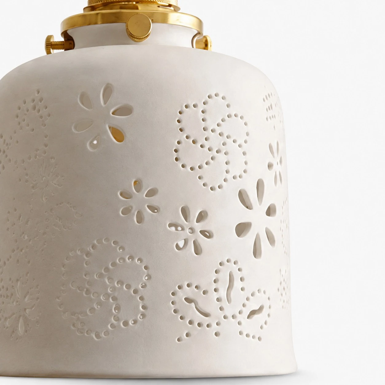 White ceramic lamp shade with perforated floral and dotted cutouts