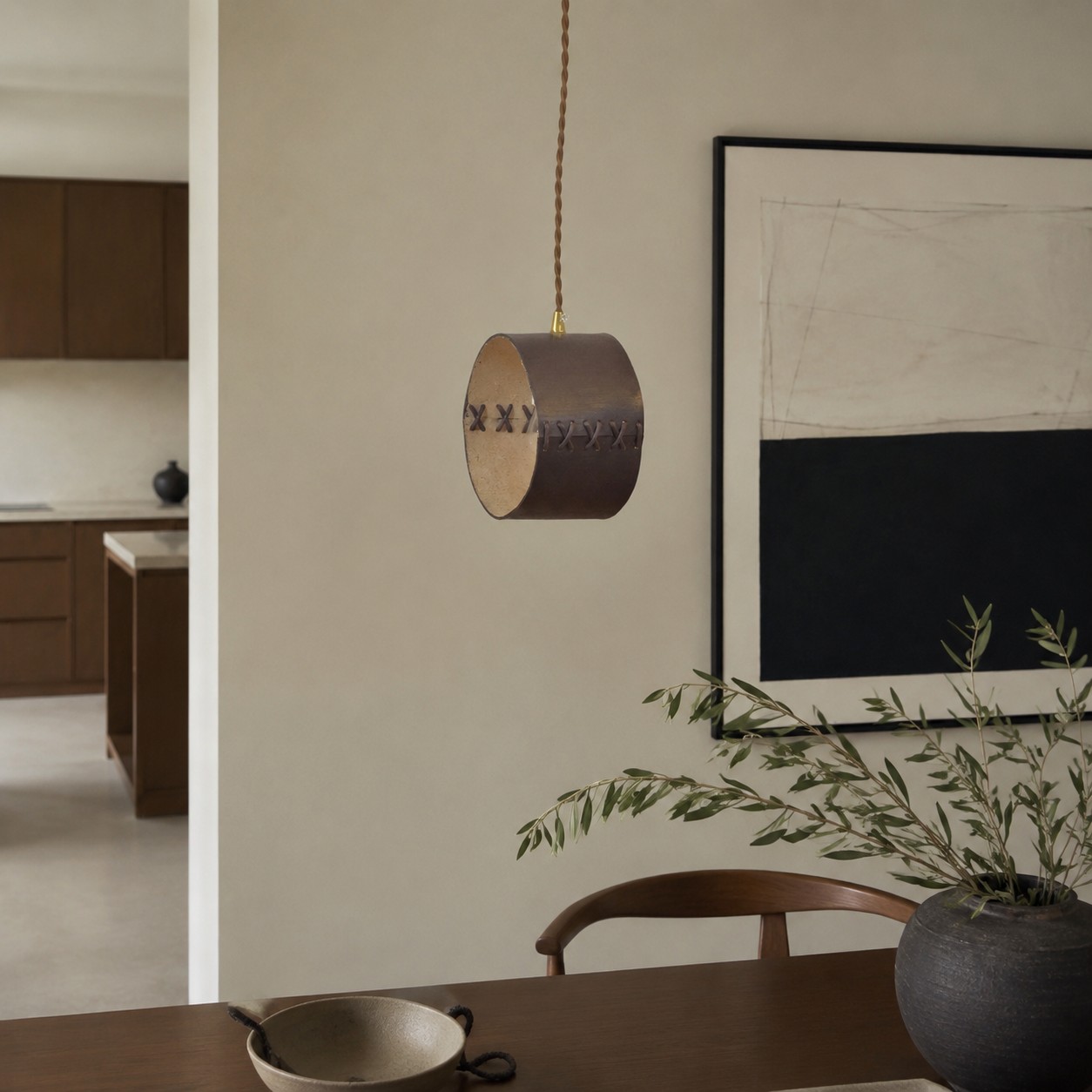 Hand-laced leather cylinder pendant light in an interior setting