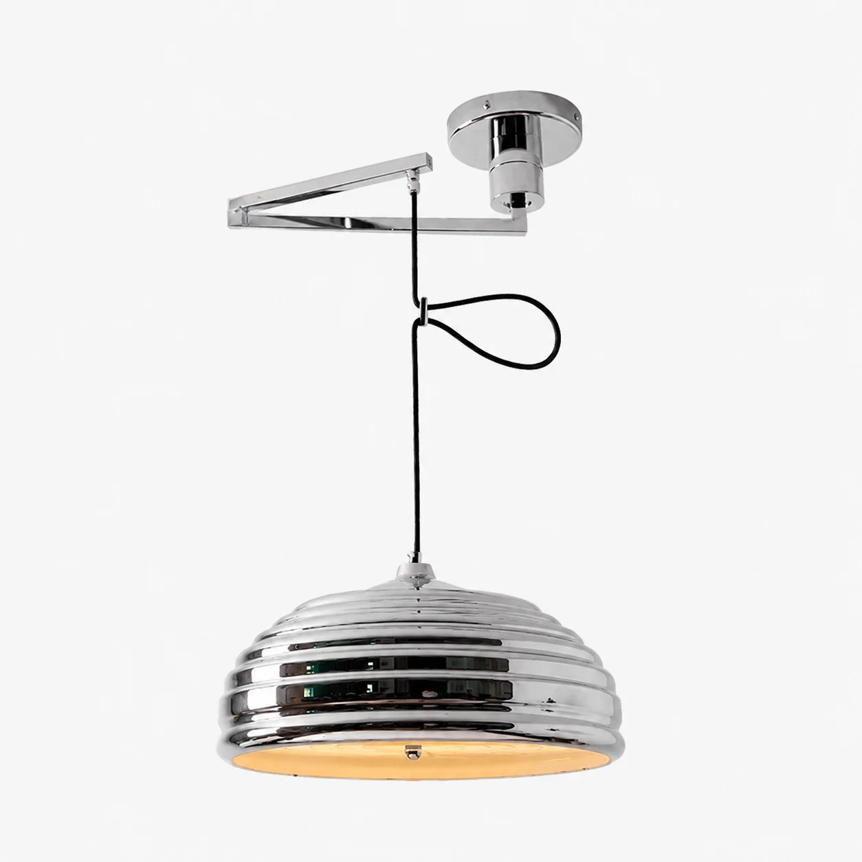 Adjustable chrome pendant light shown with a warm bulb installed