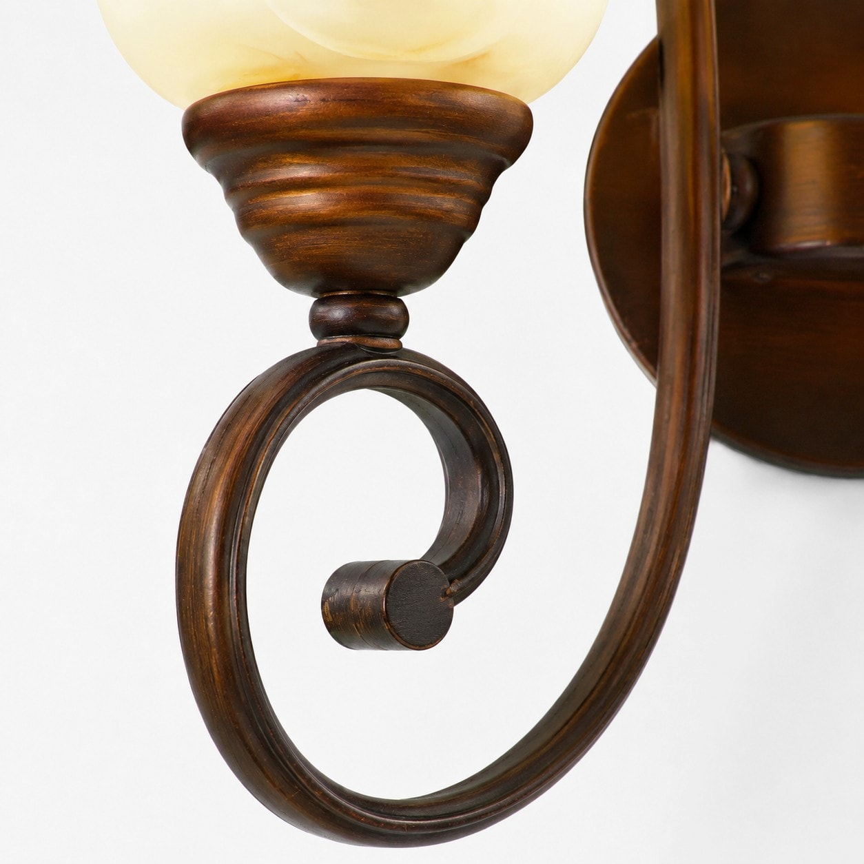 Curved bronze-tone metal arm detail