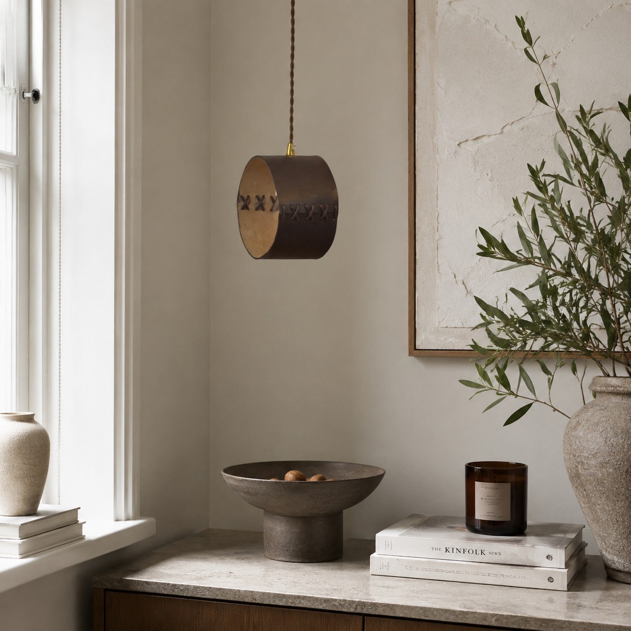 Hand-laced leather cylinder pendant light in an interior setting