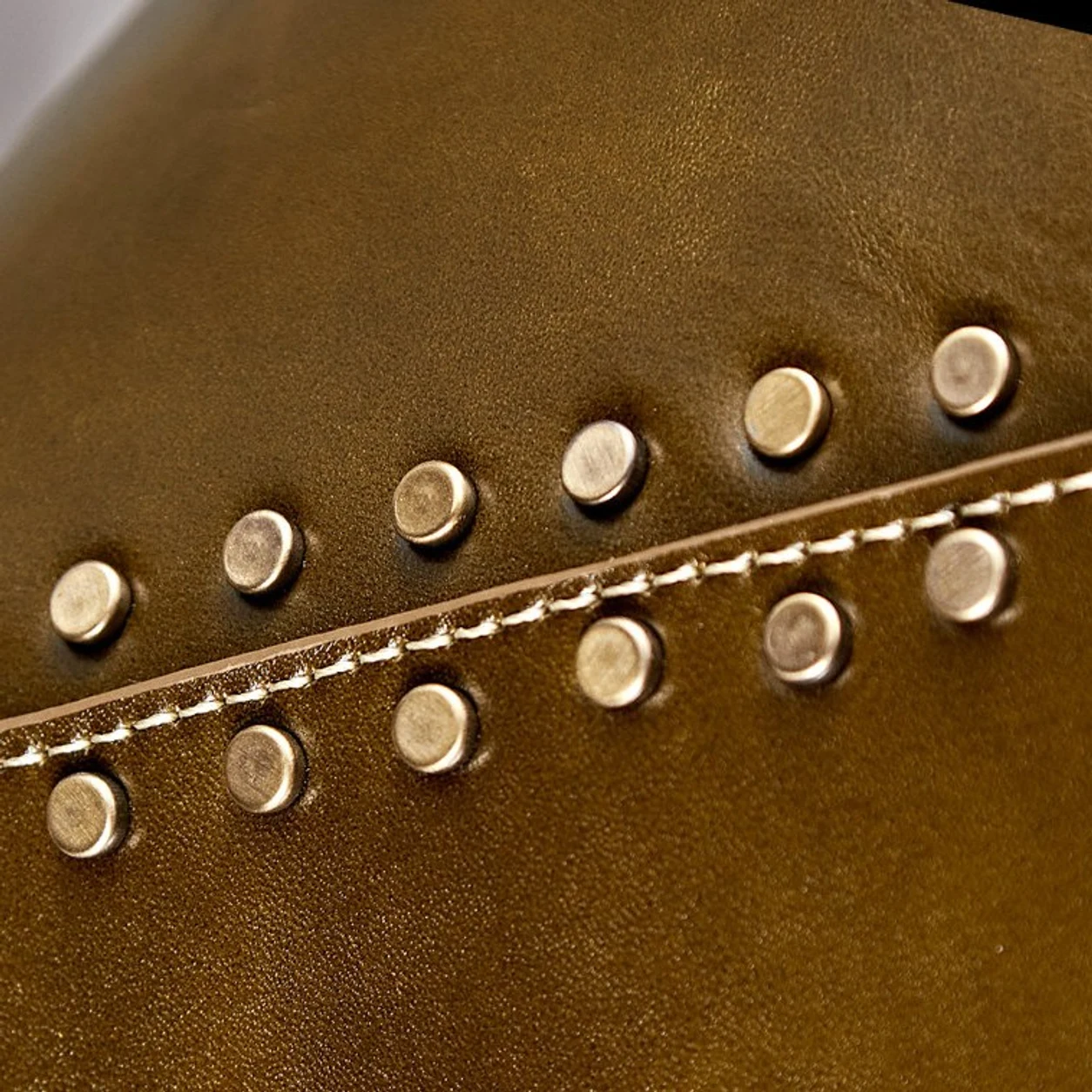 Close detail of brown leather shade with gold rivets
